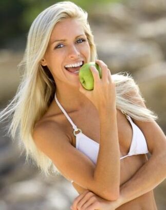 Una ragazza mangia una mela per perdere 10 kg al mese